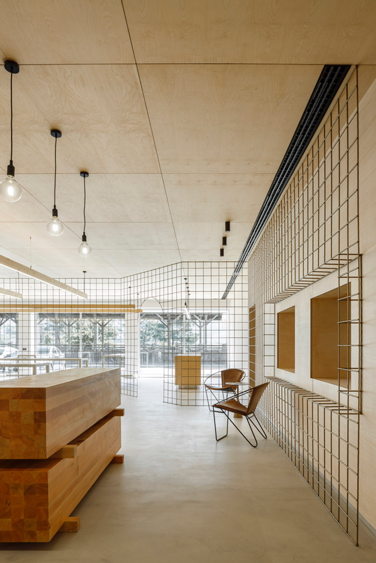 stu.dere divides interior space with golden wire meshes for multiple uses in this store in Portugal