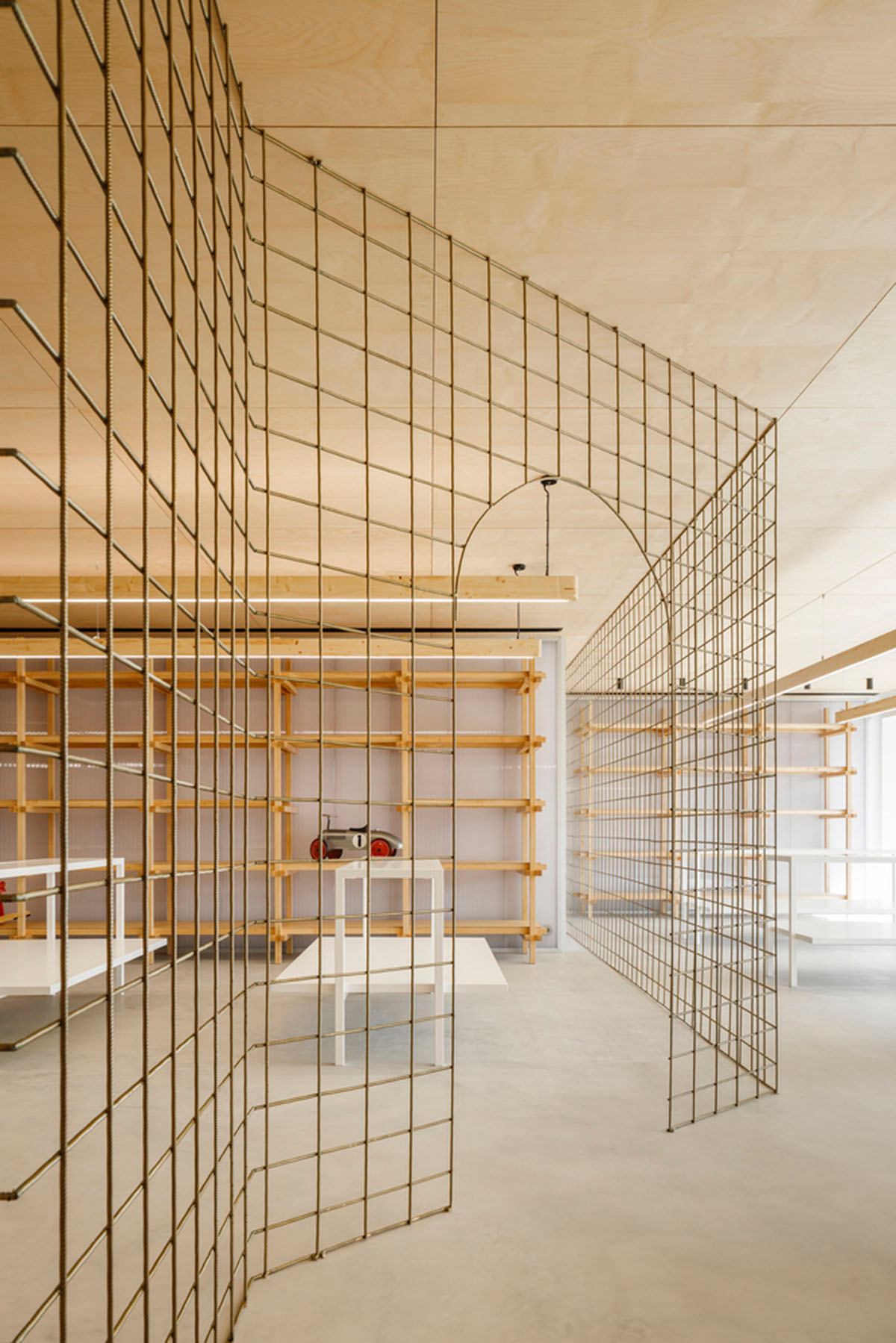 stu.dere divides interior space with golden wire meshes for multiple uses in this store in Portugal