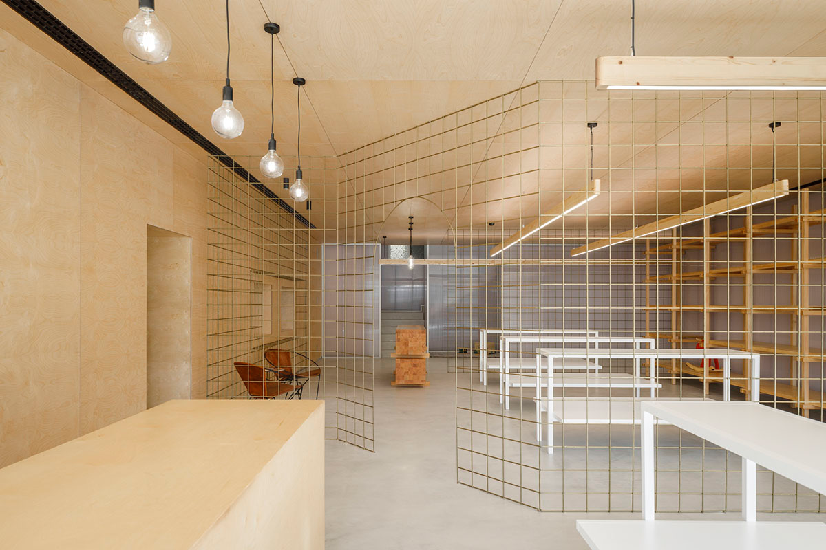 stu.dere divides interior space with golden wire meshes for multiple uses in this store in Portugal