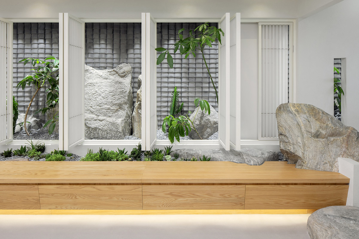 Jiejie studio wraps this tea room with a peach garden with rocky and forest landscape in Beijing