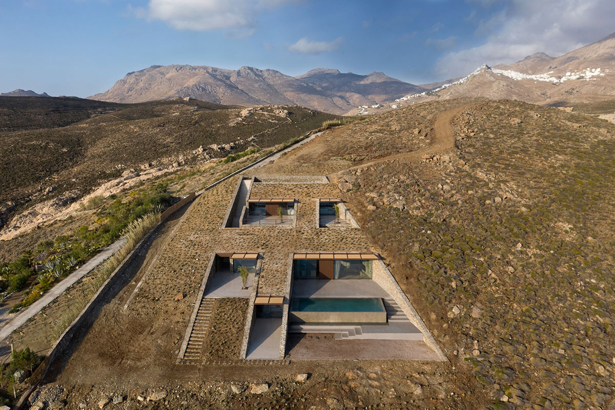 MOLD Architects used advantages of sloping land to design Ncaved house in Greece