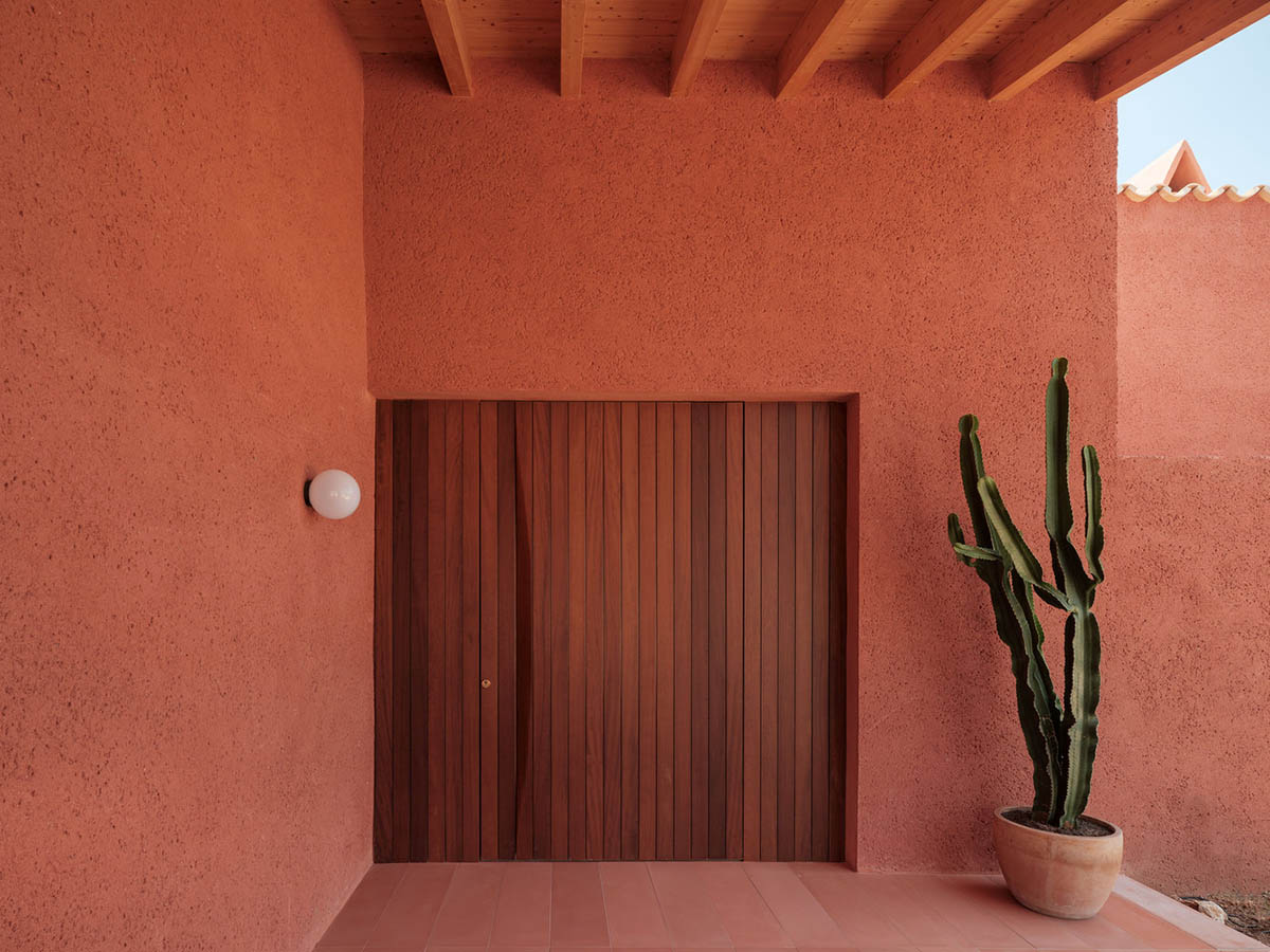 Large openings and reddish-colored façades mark this holiday home by Isla Architects in a rustic land