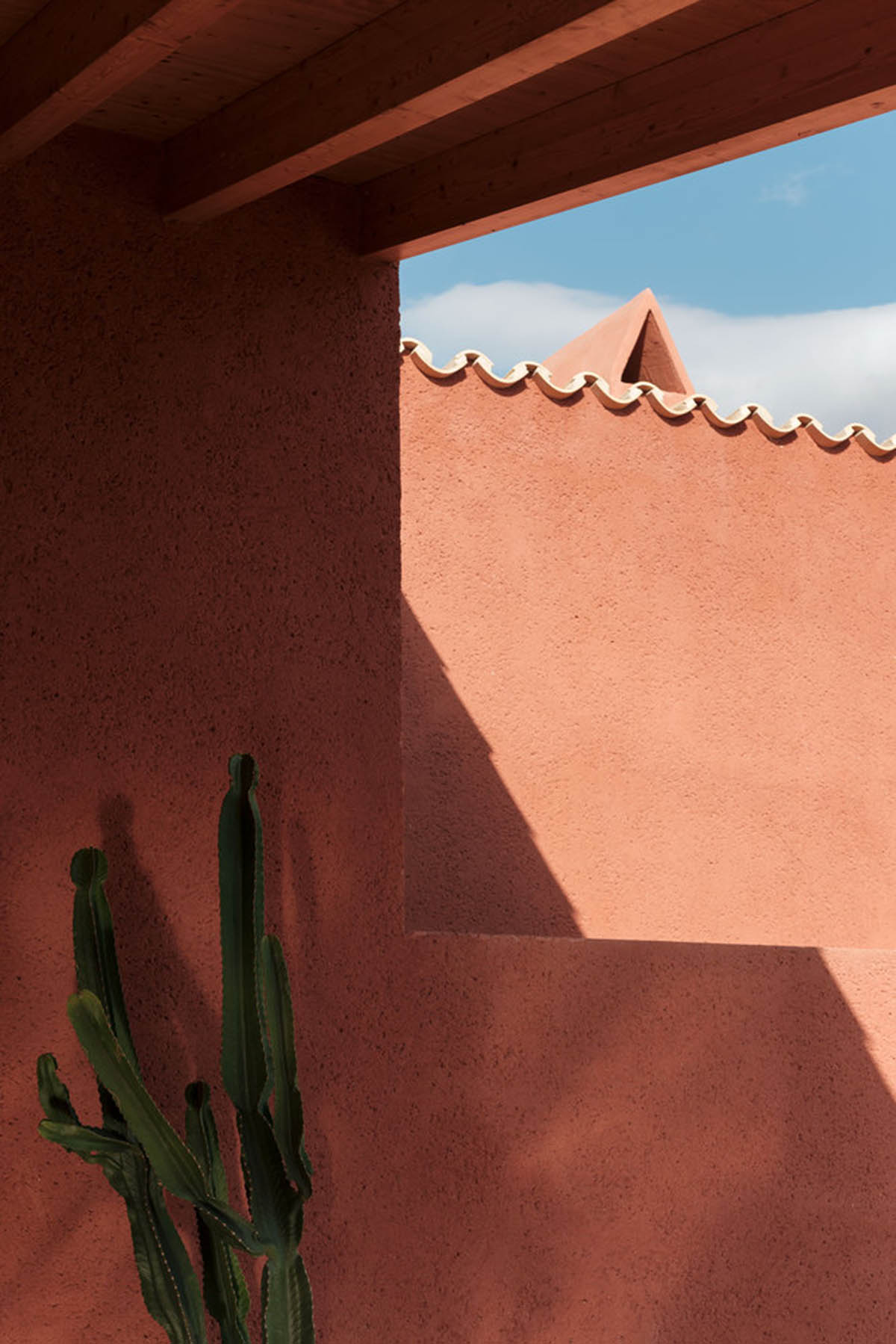 Large openings and reddish-colored façades mark this holiday home by Isla Architects in a rustic land