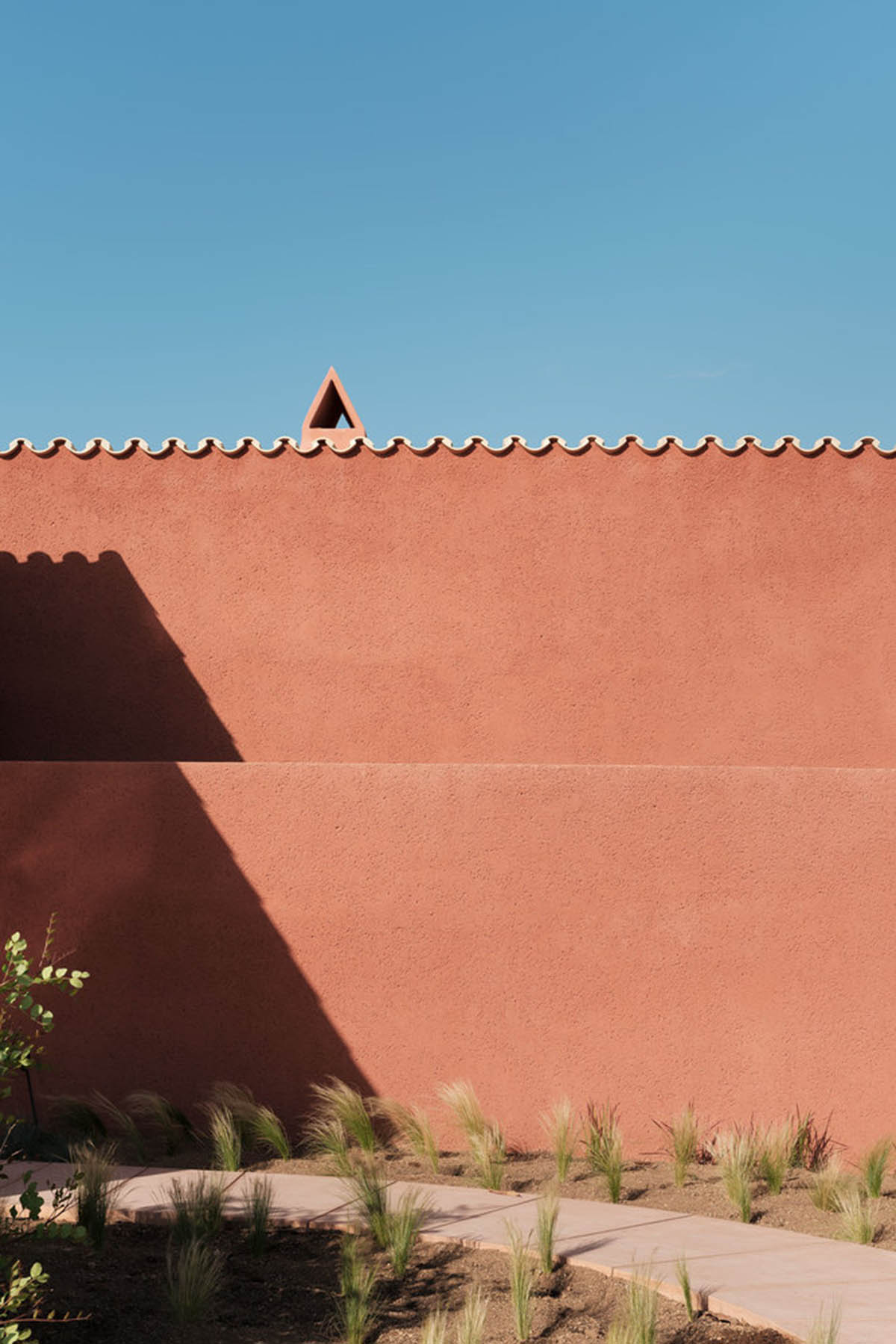 Large openings and reddish-colored façades mark this holiday home by Isla Architects in a rustic land