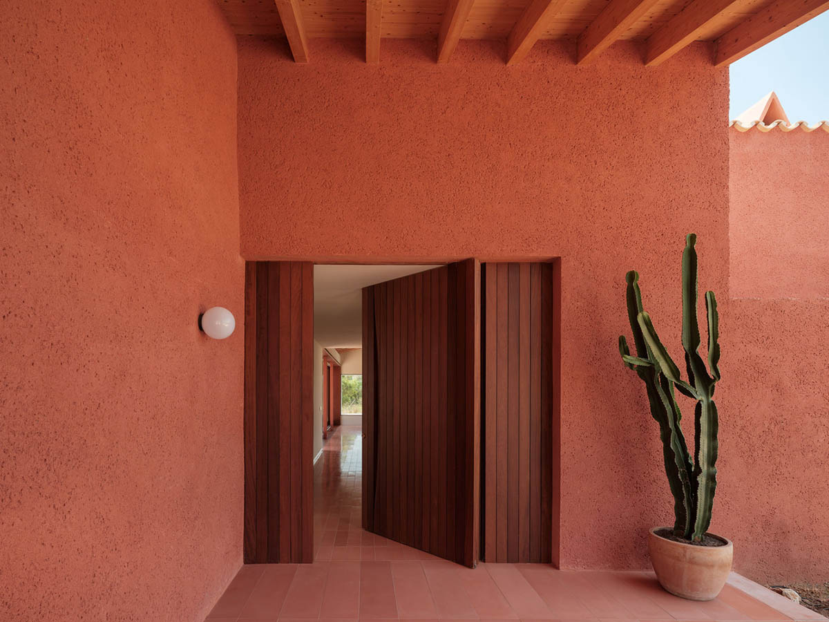 Large openings and reddish-colored façades mark this holiday home by Isla Architects in a rustic land
