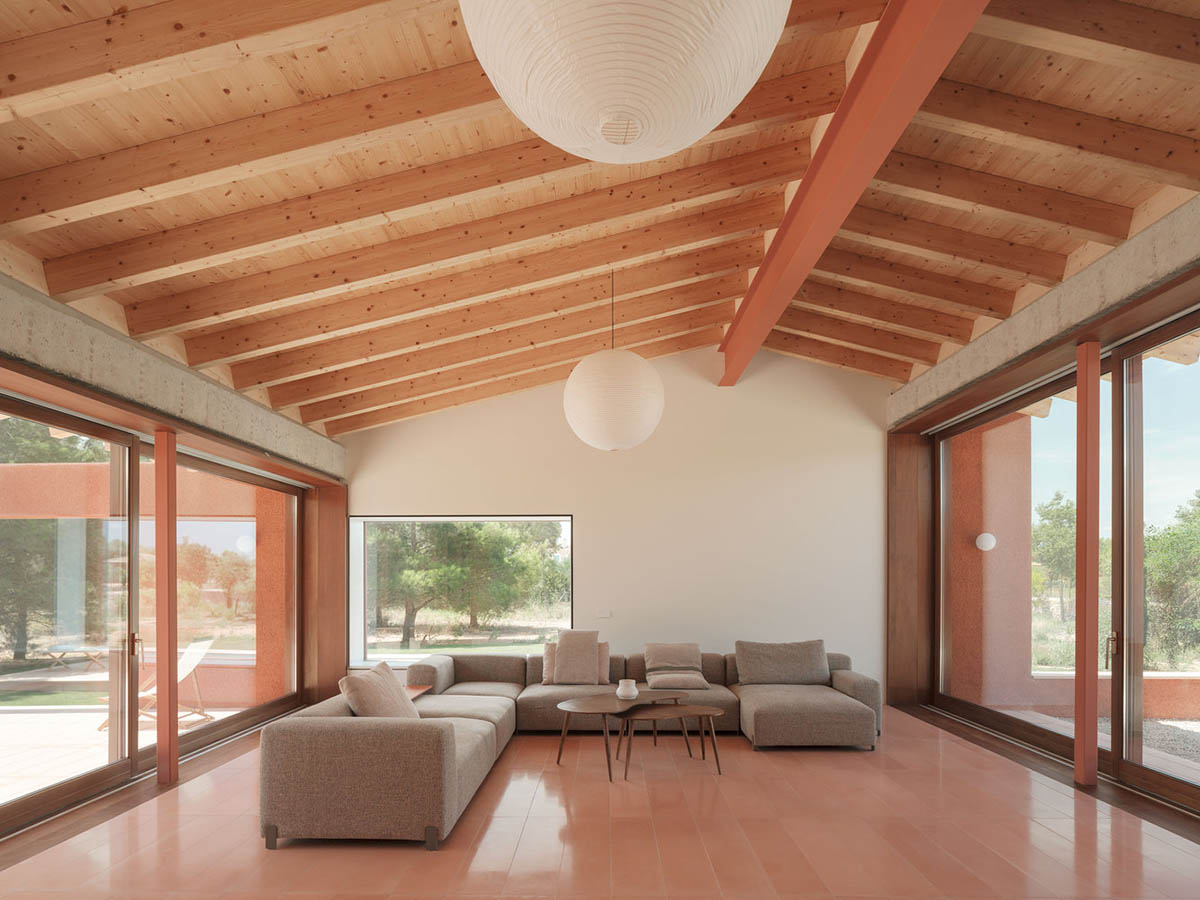 Large openings and reddish-colored façades mark this holiday home by Isla Architects in a rustic land