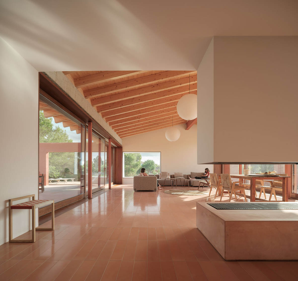 Large openings and reddish-colored façades mark this holiday home by Isla Architects in a rustic land