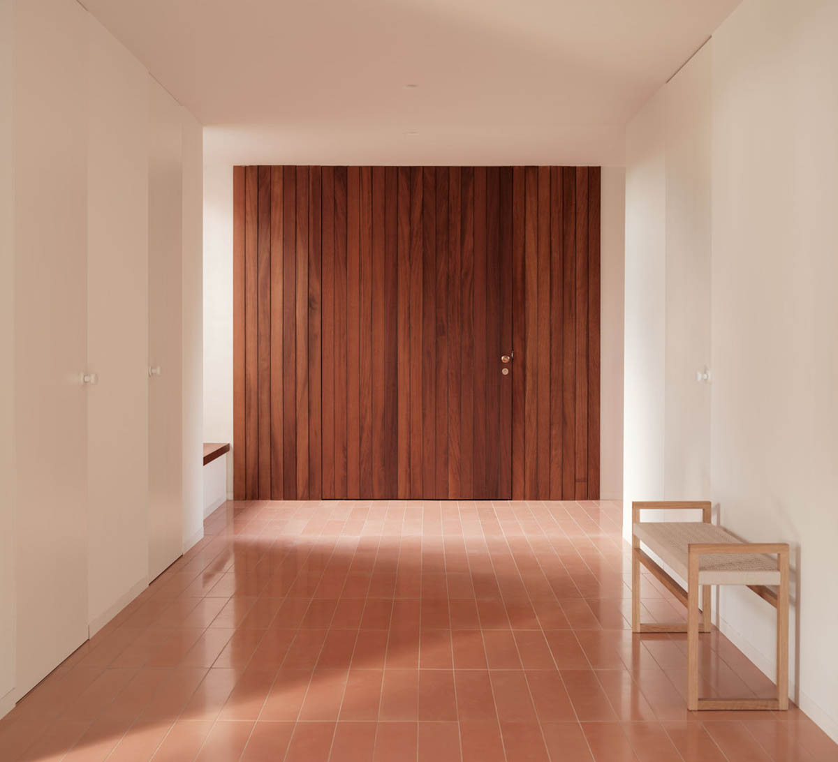 Large openings and reddish-colored façades mark this holiday home by Isla Architects in a rustic land