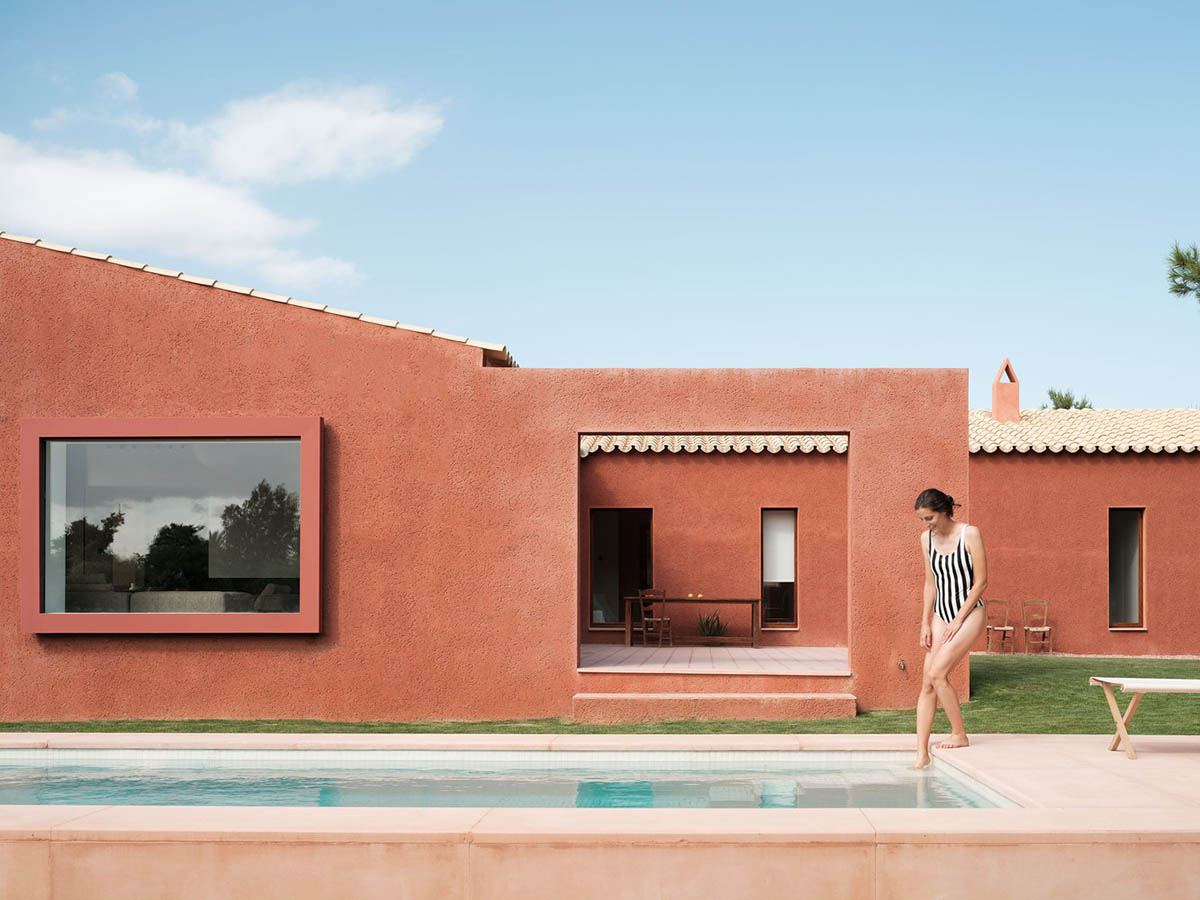 Large openings and reddish-colored façades mark this holiday home by Isla Architects in a rustic land
