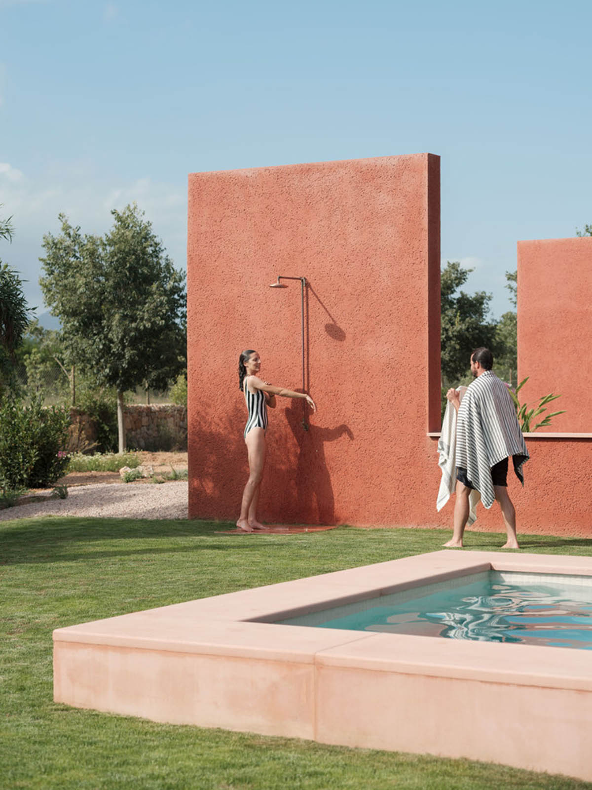 Large openings and reddish-colored façades mark this holiday home by Isla Architects in a rustic land