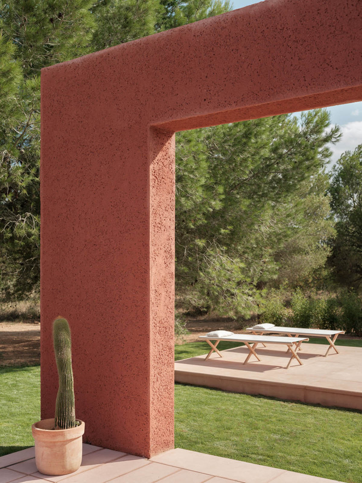 Large openings and reddish-colored façades mark this holiday home by Isla Architects in a rustic land