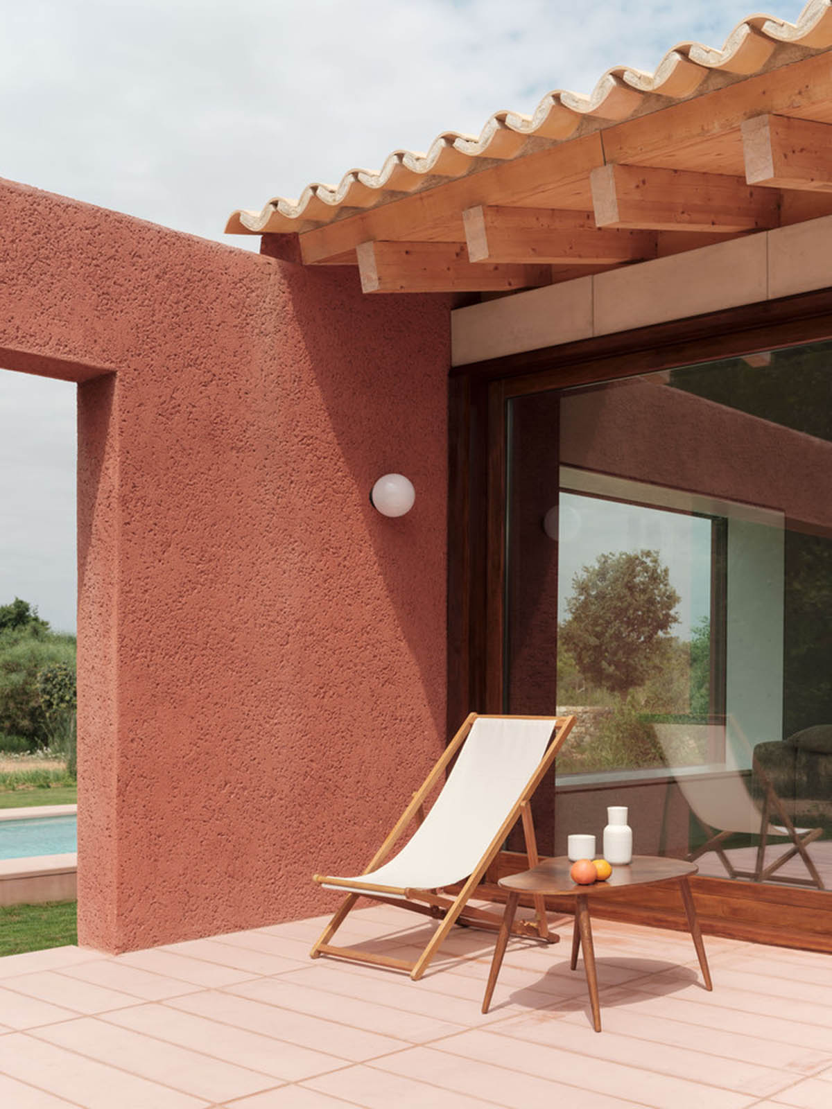 Large openings and reddish-colored façades mark this holiday home by Isla Architects in a rustic land