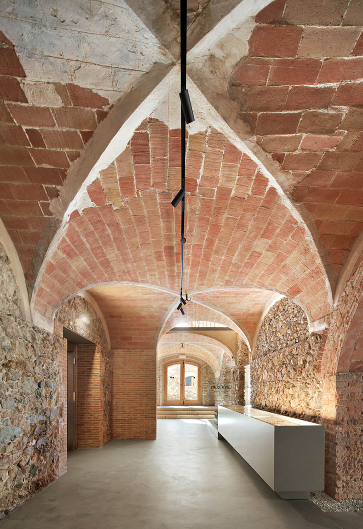 Aigua de Vilaju&iuml;ga restored with vaulted bricks and exposed concrete bringing light into the space