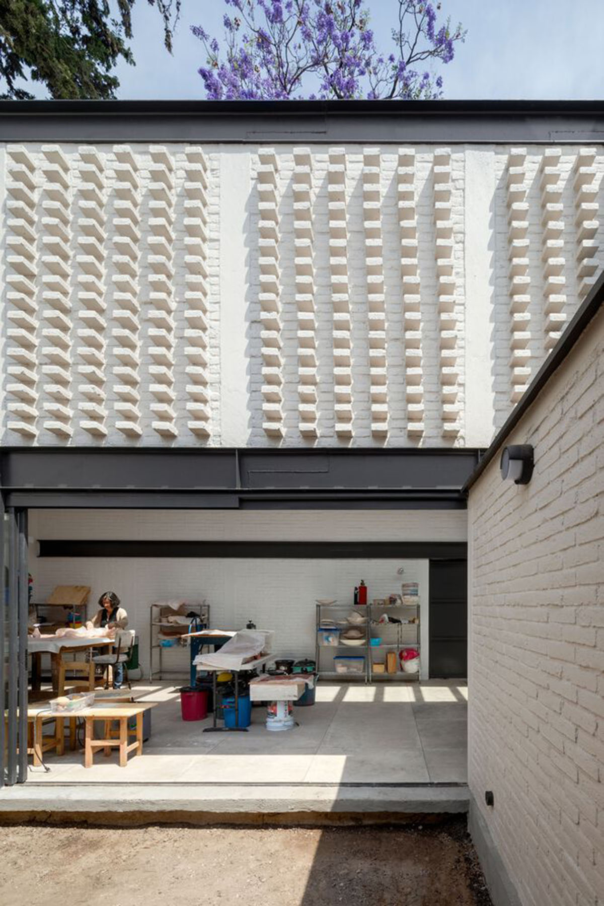 Sculptor's home studio features industrial saw-tooth roofs creating breathing interiors in Mexico