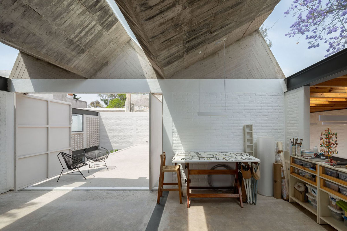 Sculptor's home studio features industrial saw-tooth roofs creating breathing interiors in Mexico