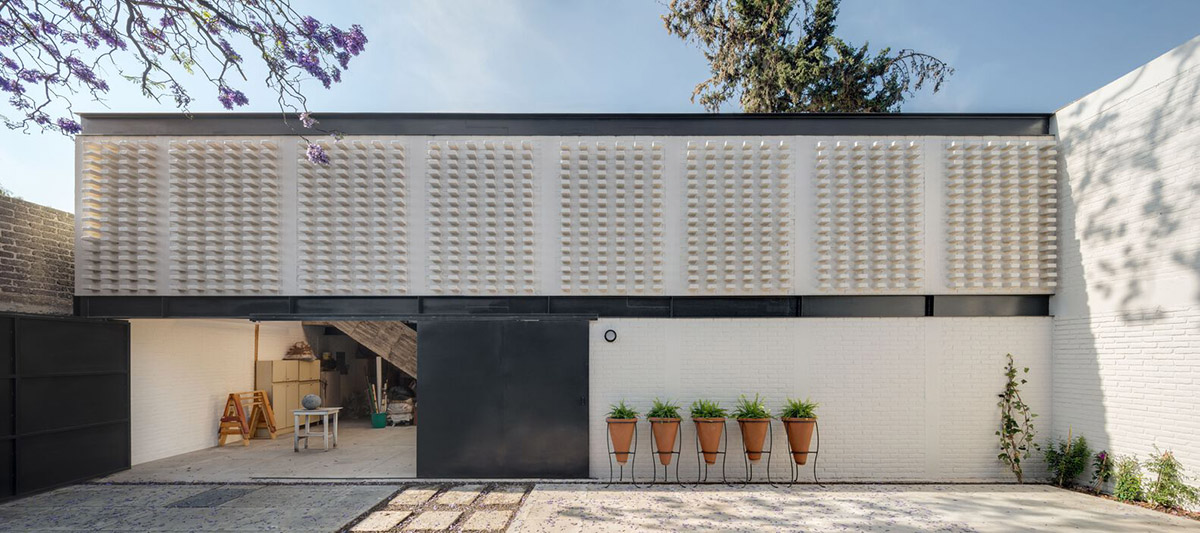 Sculptor's home studio features industrial saw-tooth roofs creating breathing interiors in Mexico
