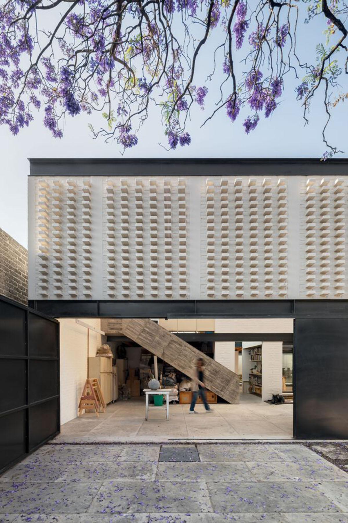 Sculptor's home studio features industrial saw-tooth roofs creating breathing interiors in Mexico
