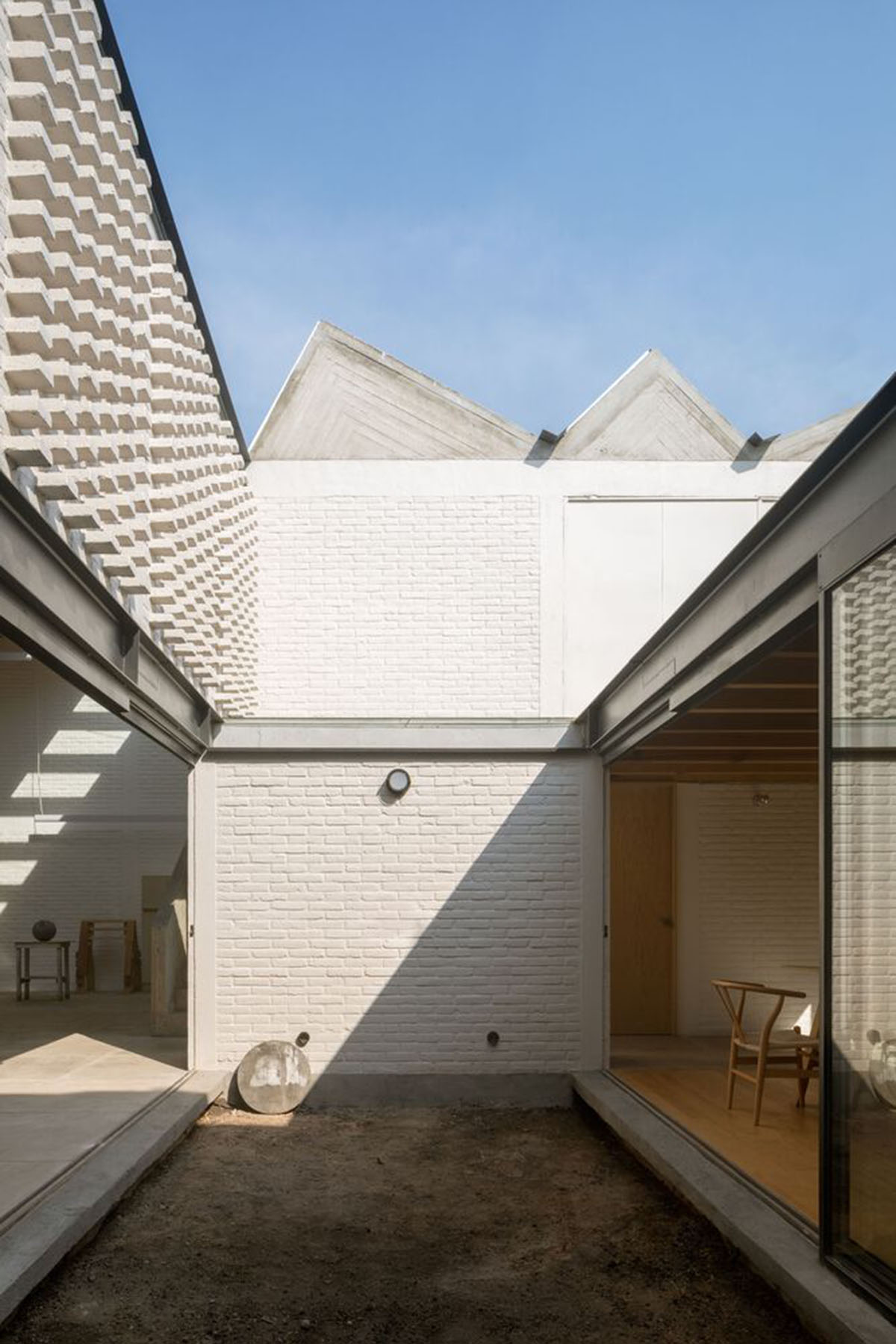 Sculptor's home studio features industrial saw-tooth roofs creating breathing interiors in Mexico