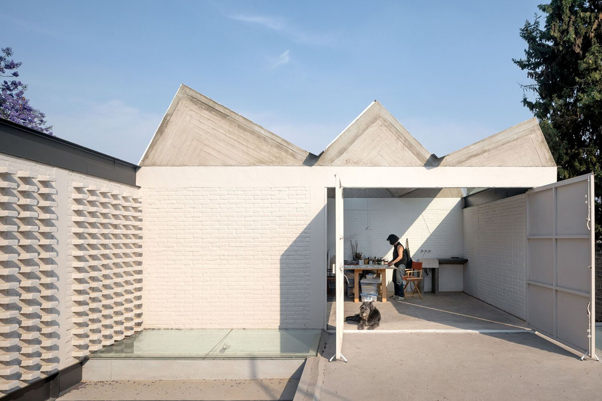 Sculptor's home studio features industrial saw-tooth roofs creating breathing interiors in Mexico