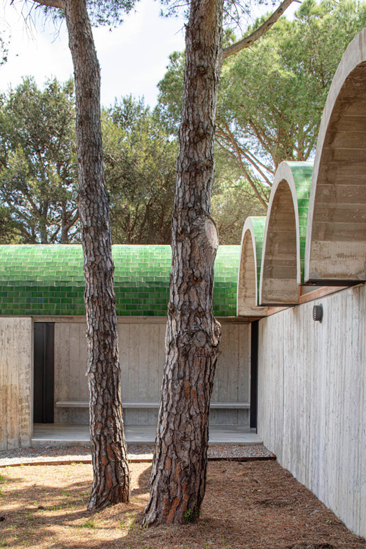 Summer house by BELLAFILARQUITECTES features semicircular vaults clad in green tiles in Spain