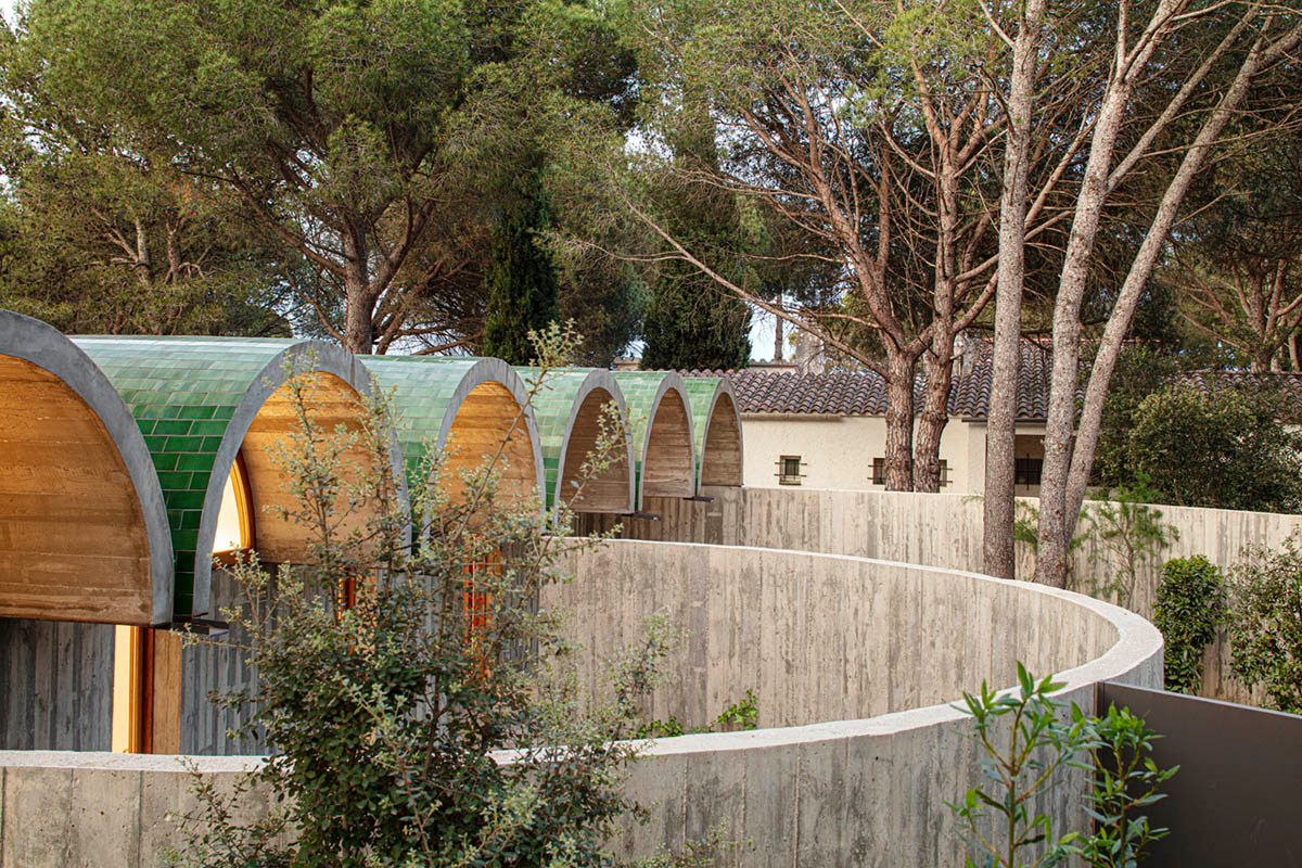 Summer house by BELLAFILARQUITECTES features semicircular vaults clad in green tiles in Spain