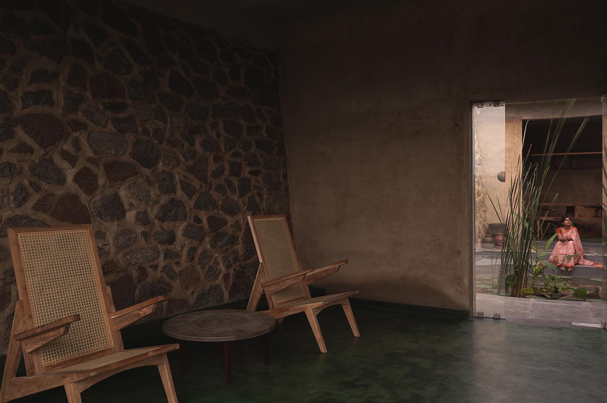 Farm house by Earthscape Studio is wrapped by gabion wall to filter light and airflow in India 