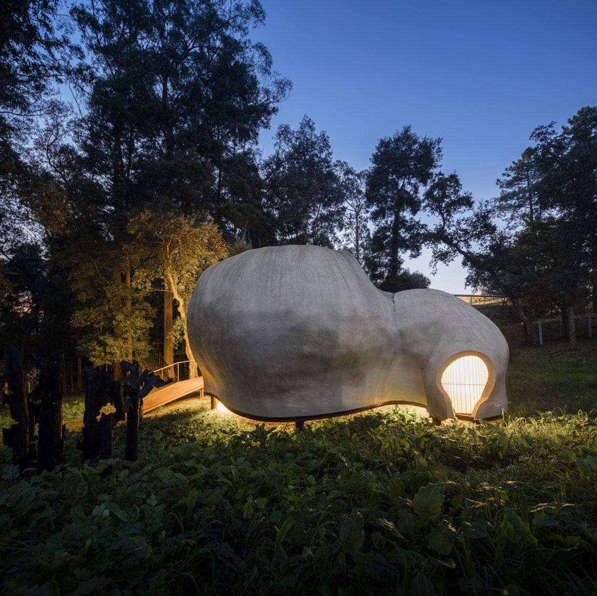 Super small cave-like art gallery by FCC Arquitectura built on lush green in Portugal
