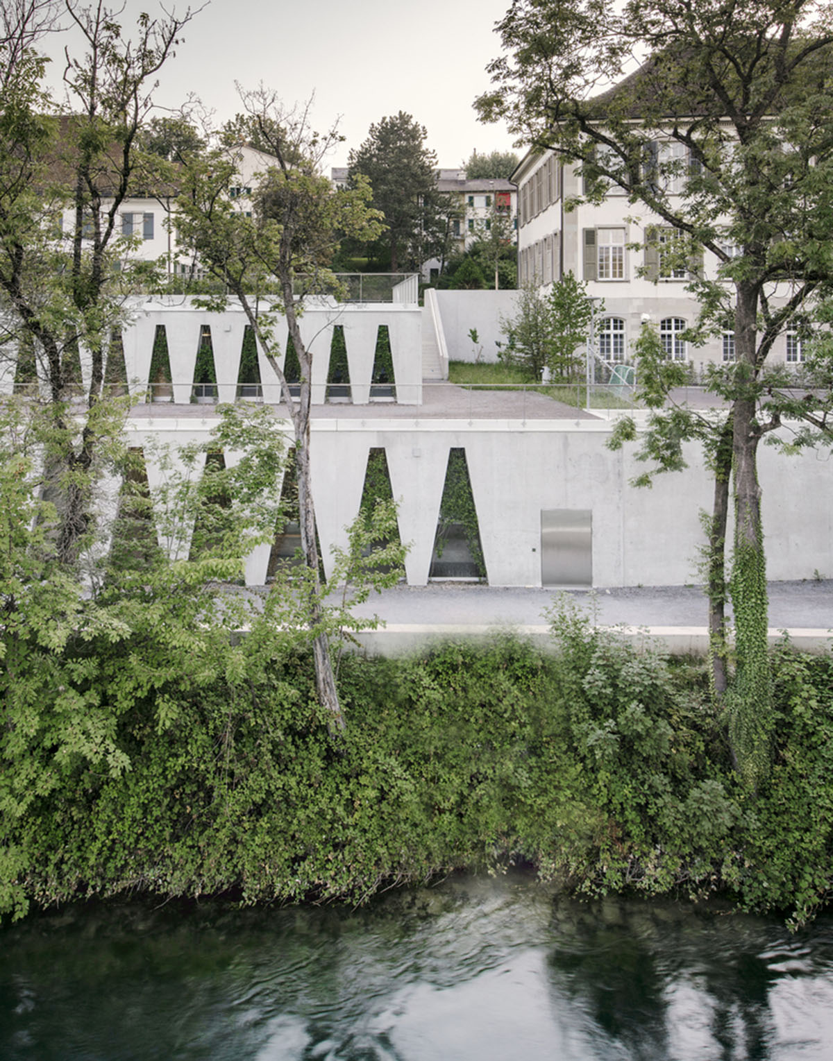 Trapezoidal openings characterize the interiors of cultural center by Estudio Barozzi Veiga in Zürich