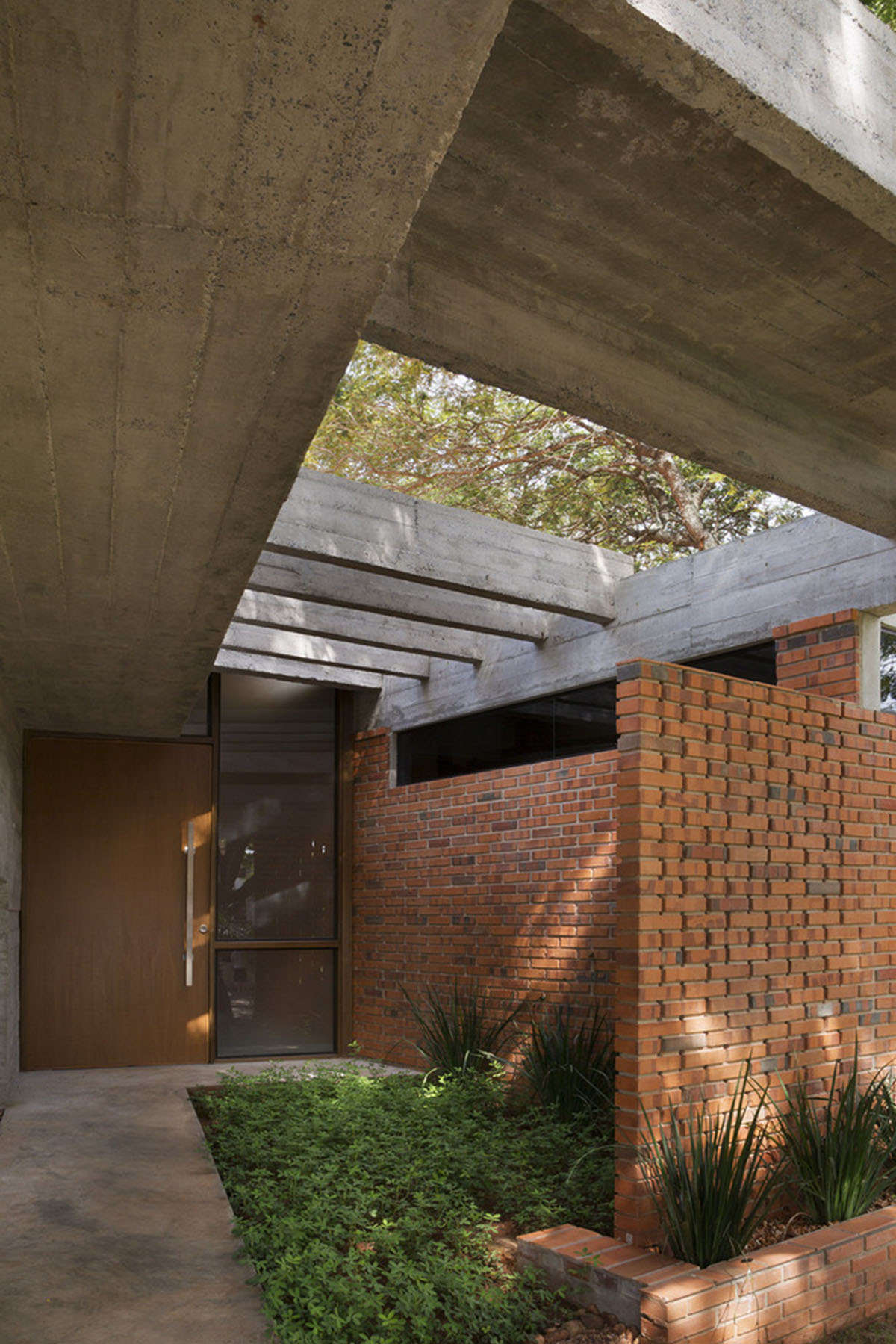 Concrete roof slabs and surfaces freely fly over this brick house in Paraguay by Culata Jovái Group