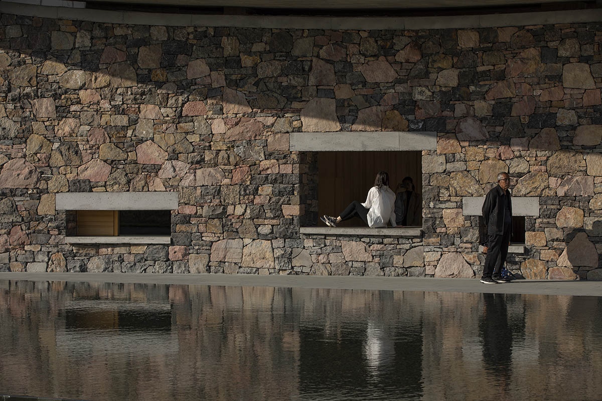 Concrete hyperboloid roofs cover masonry stone art center with a central courtyard in Shandong