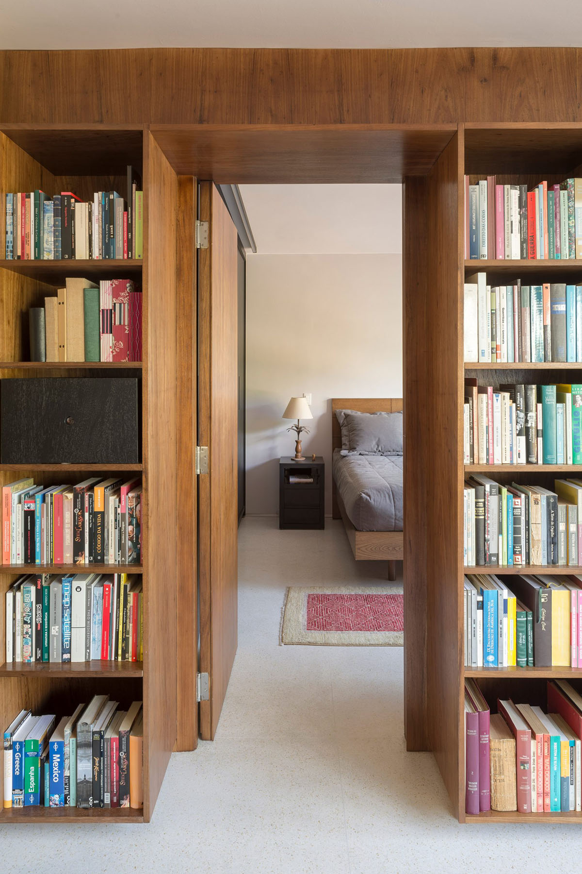 A historic Brazilian apartment has been redesigned with wooden bookcase as main divider