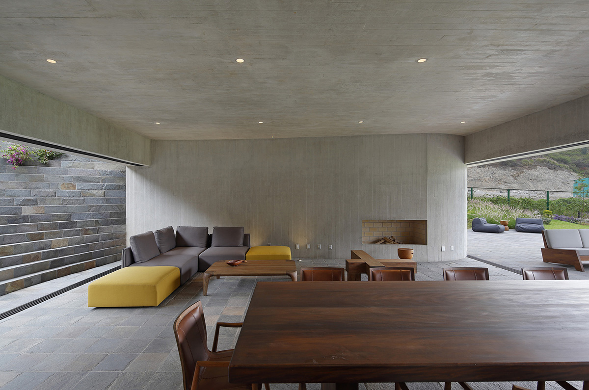 Large semi-buried social space creates a rustic and organic feeling under wooden volume built in Peru