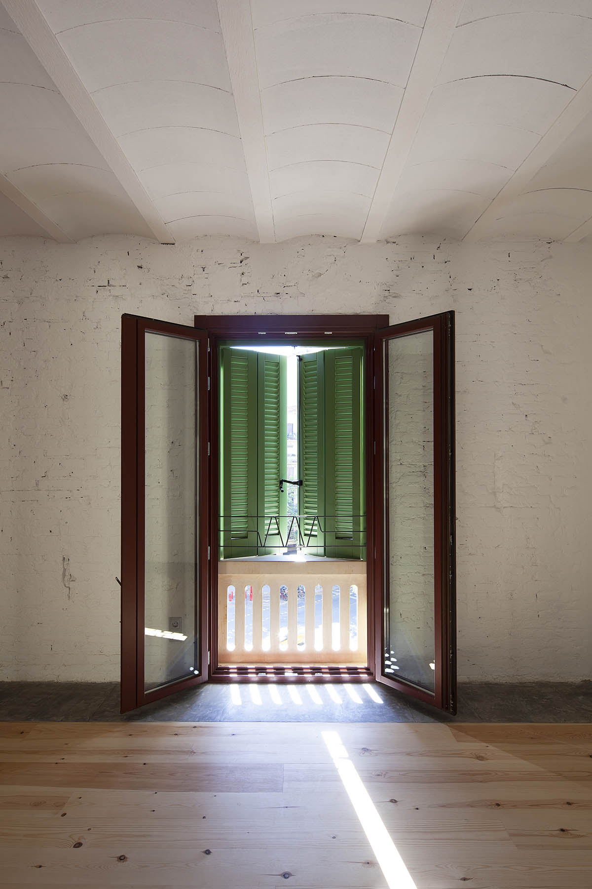 La Carboneria housing block features a dramatic courtyard with crossing beams in Barcelona