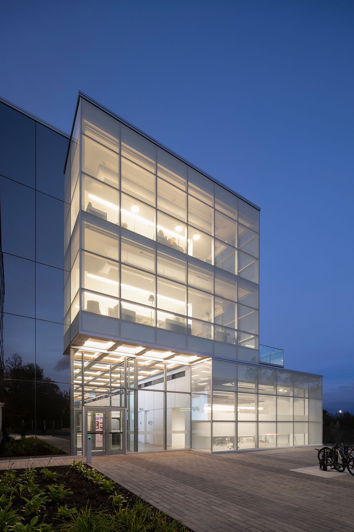 Whitish glass library designed by ACDF Architecture acts as a white floating volume in Quebec