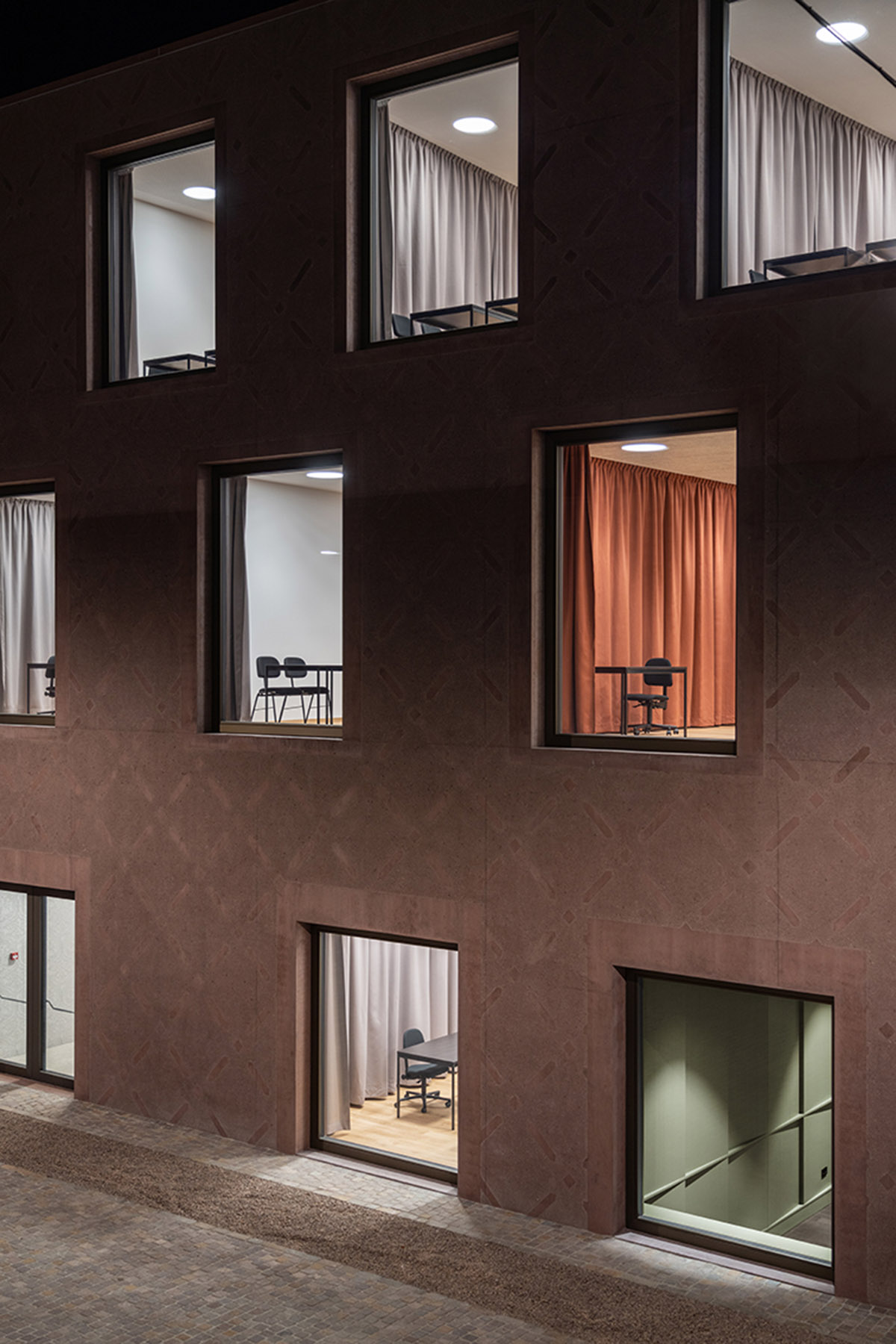 Carlana Mezzalira Pentimalli built music school with cut out and red-pigmented volumes in Italy