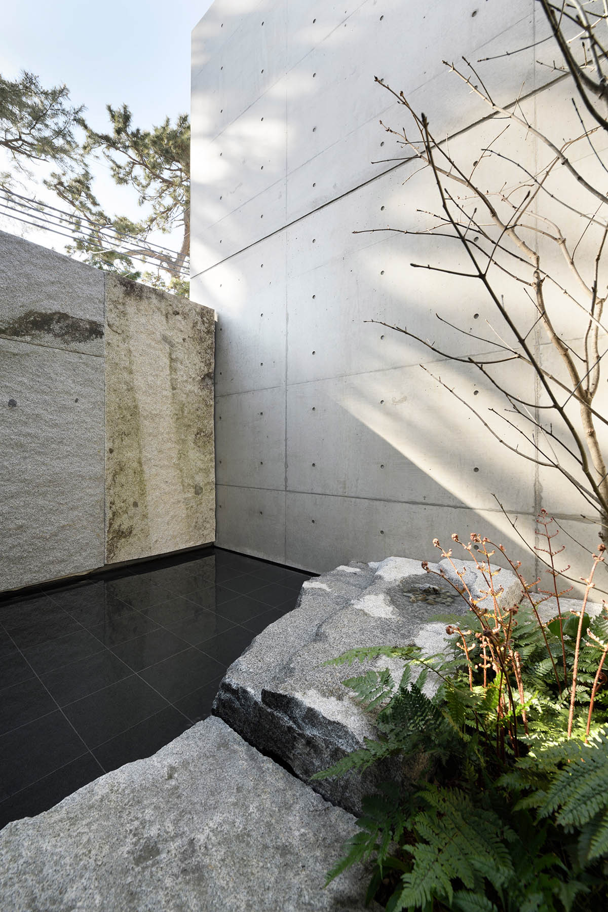 Gosize combines its office and residence on a natural stone base in Japan