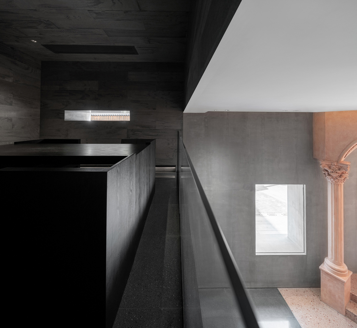 Pink elements and dark colors create sharp contrast in the interiors of restaurant and showroom