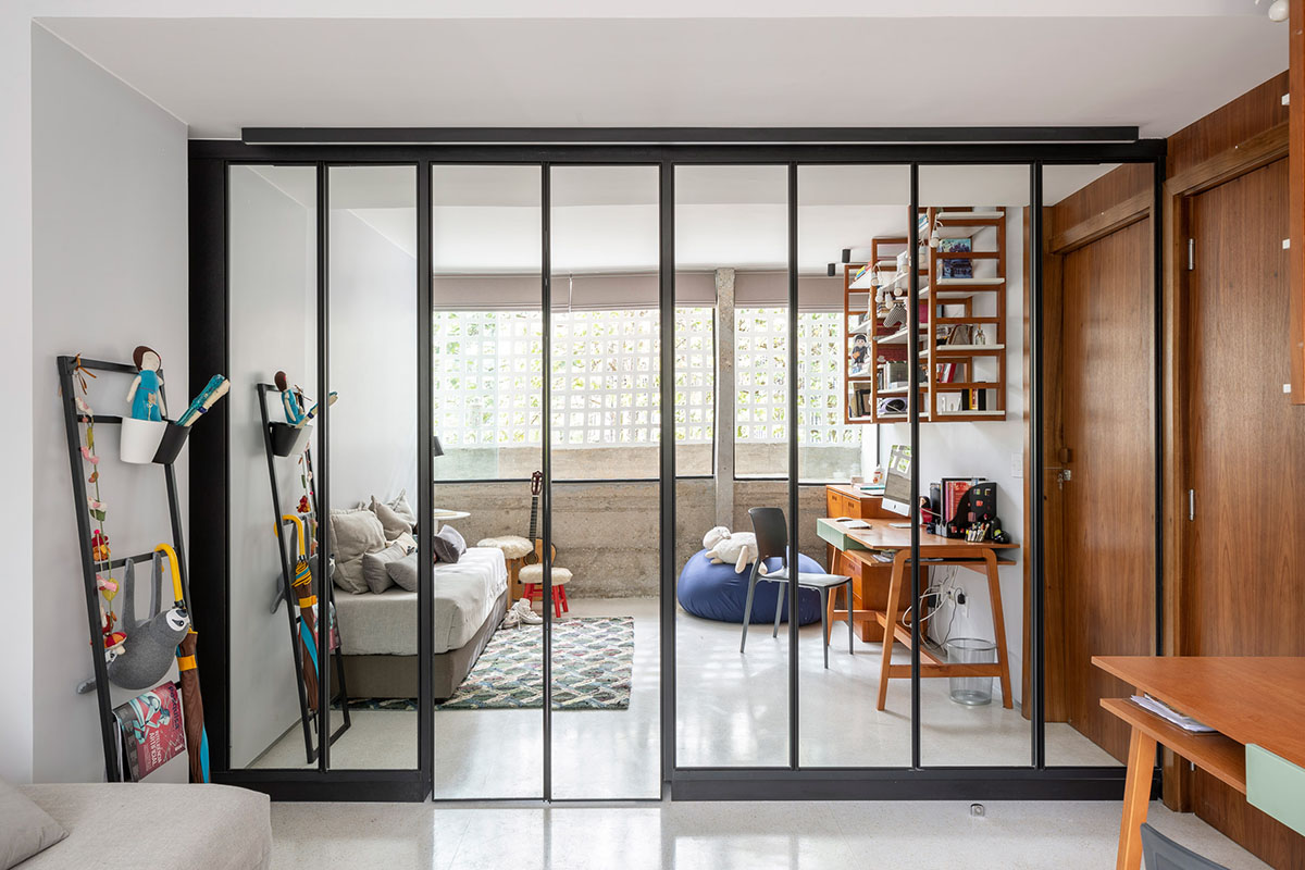 A historic Brazilian apartment has been redesigned with wooden bookcase as main divider