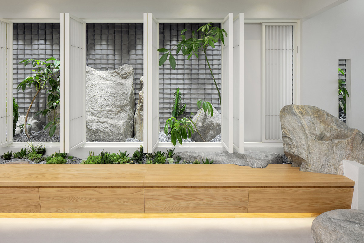 Jiejie studio wraps this tea room with a peach garden with rocky and forest landscape in Beijing
