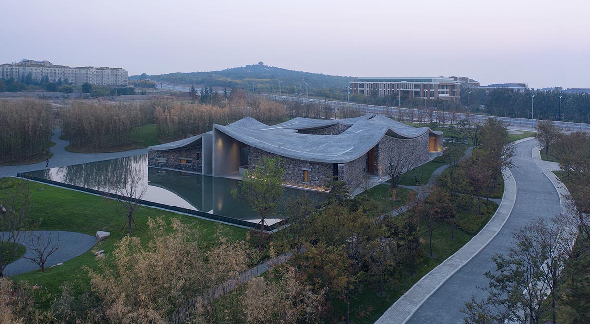 Concrete hyperboloid roofs cover masonry stone art center with a central courtyard in Shandong