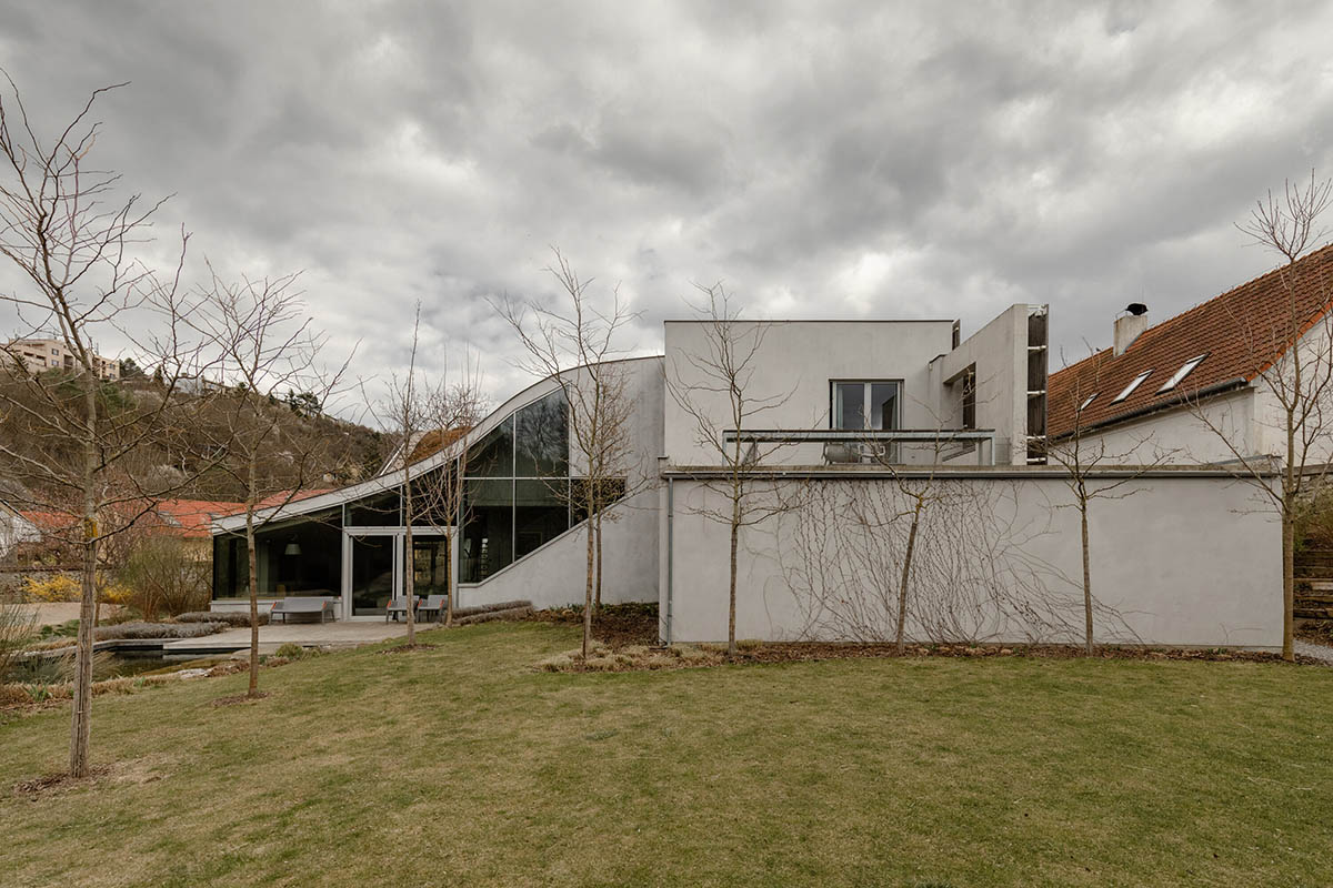 Family house by RO_AR merges two geometries with undulating grass-filled roof in the Czech Republic