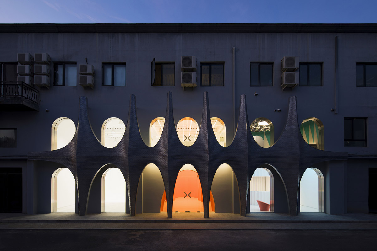 123 architects converts industrial building into photography studio featuring arched addition