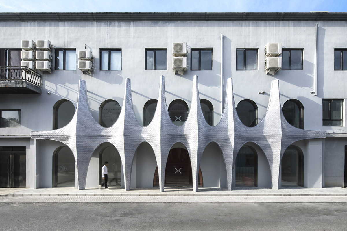 123 architects converts industrial building into photography studio featuring arched addition