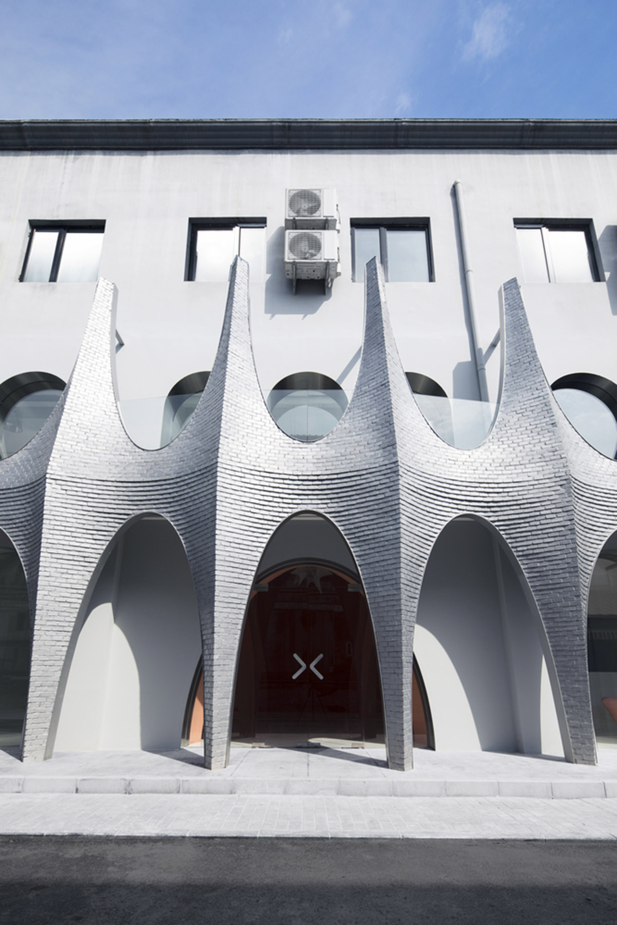 123 architects converts industrial building into photography studio featuring arched addition