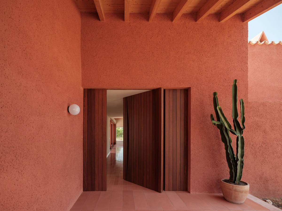 Large openings and reddish-colored façades mark this holiday home by Isla Architects in a rustic land