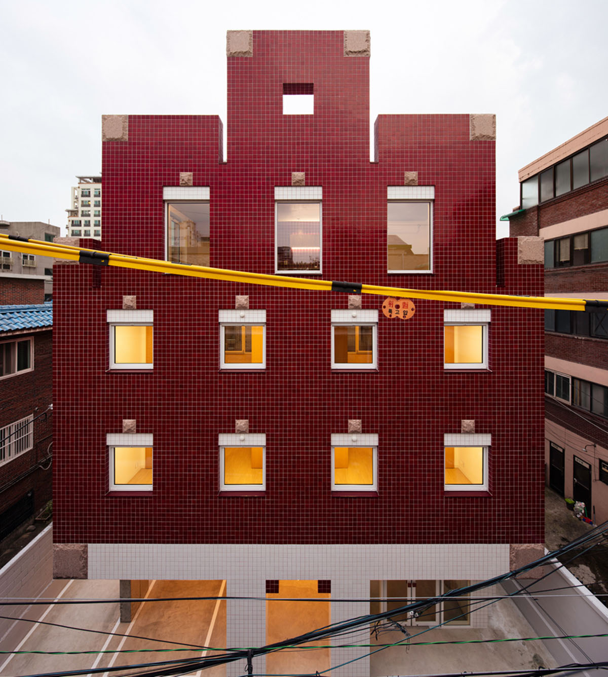 aoa architects uses red marble tiles to clad this apartment in South Korean neighborhood