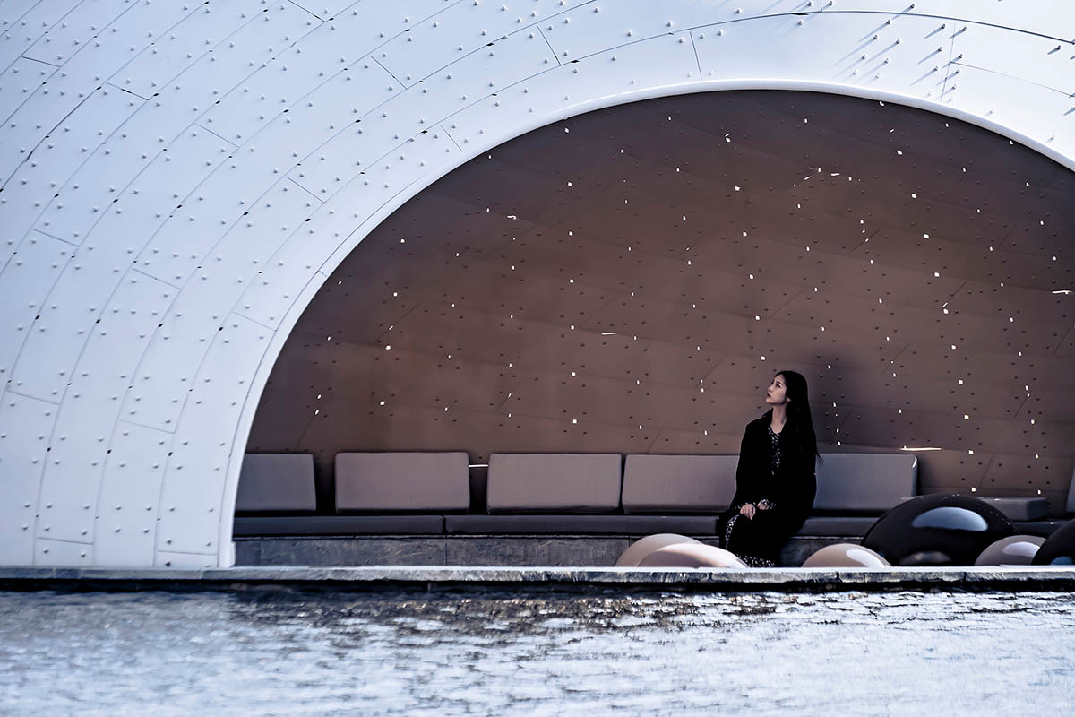   A thin-shell pavilion inspired by the bionic weaving appearance of birds' nests sits on a pool 