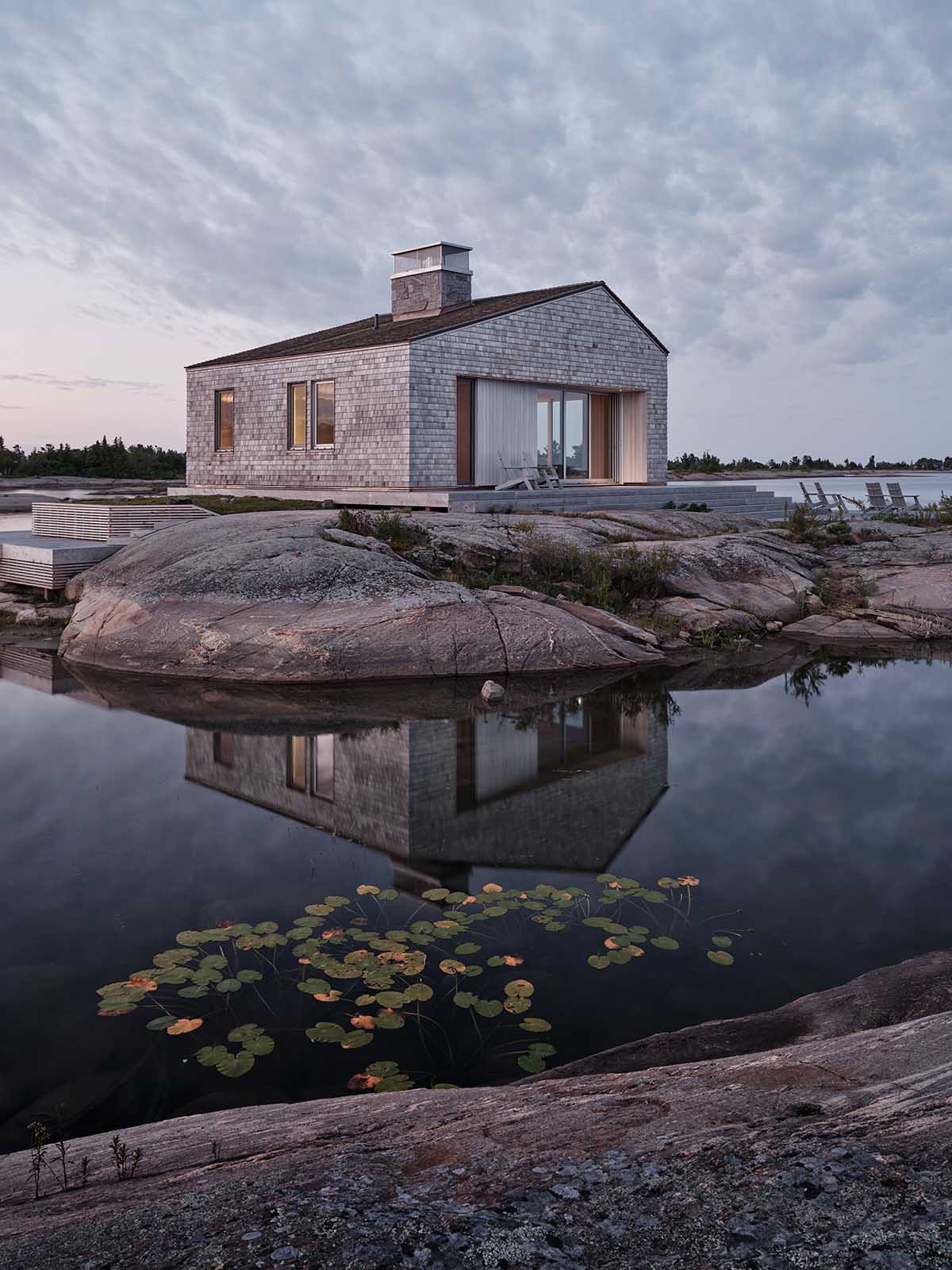 Akb Architects built cottage that blends with brownish-grey rocks in its surrounding