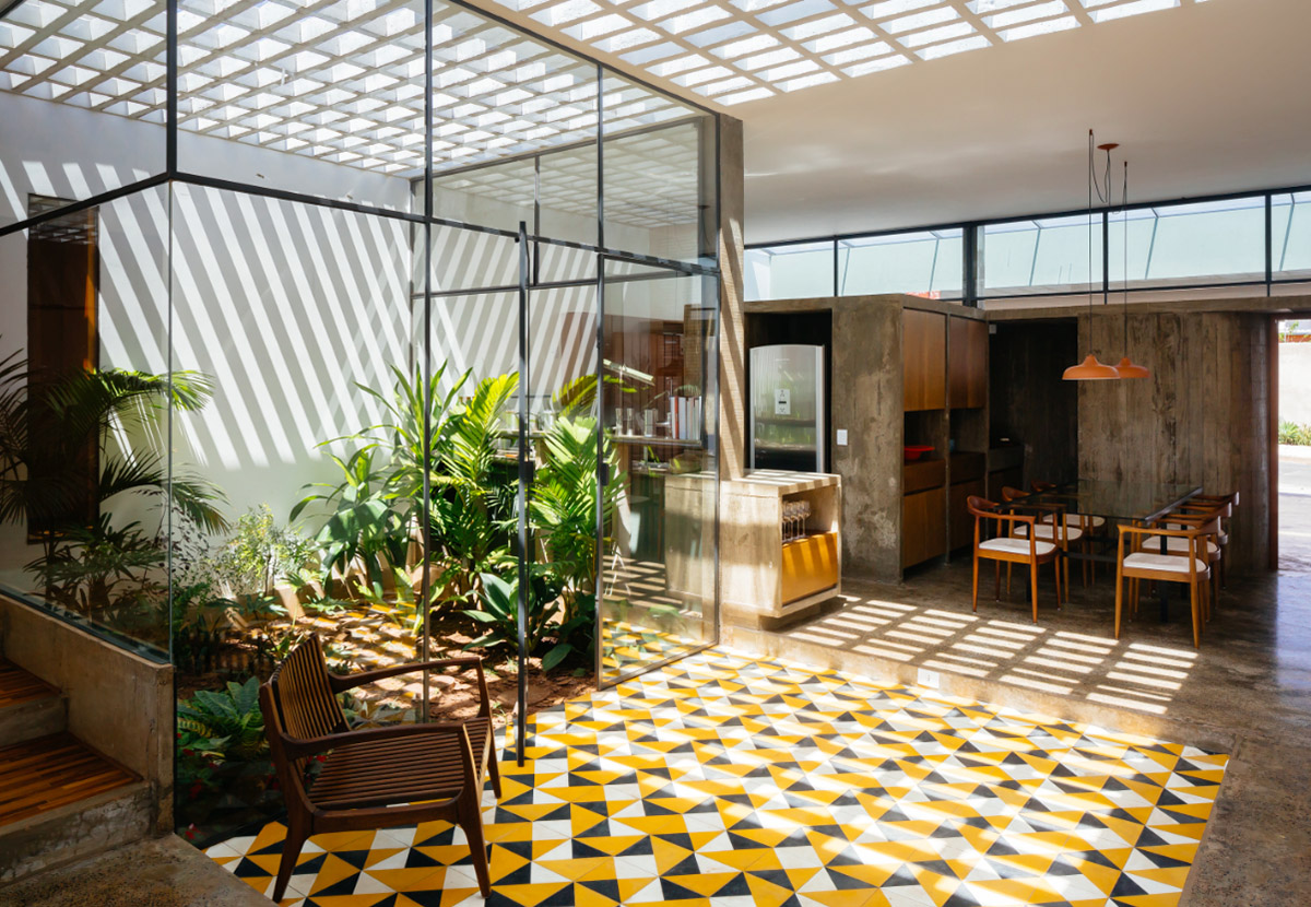 V&atilde;o designed recessed volumes and leaning red wall to offer flexible spaces for this Brazilian house