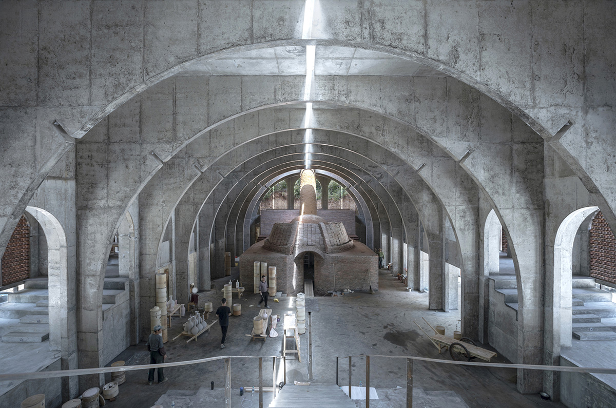 AZL Architects renovates old kiln building with concrete and brick arches in the middle of a forest